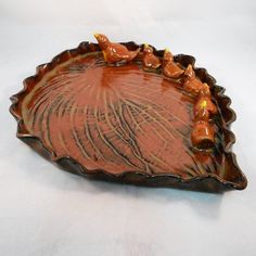 a brown decorative dish with birds on it