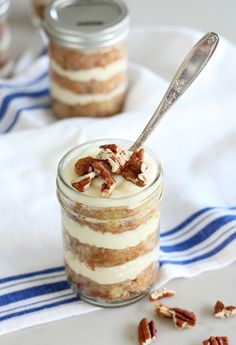 a jar filled with dessert sitting on top of a white table next to a blue and white towel