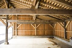 an empty garage with wood paneling on the ceiling