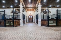 the inside of a horse barn with wooden stalls and doors on either side of it