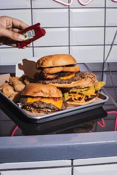 a tray filled with hamburgers and fries on top of a counter