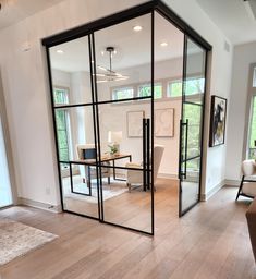 a living room filled with furniture and lots of glass doors on the door to another room