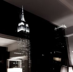 a black and white photo of the empire building in new york city at night time