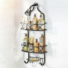 a bathroom shelf with soap, shampoo and lotion bottles on it next to a shower head