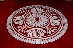 an intricately designed white plate on a red background