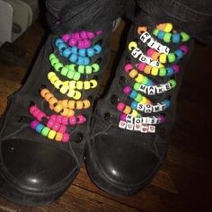 someone wearing black shoes with colorful beads on them