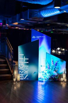 an empty stage set up for a business event with blue lighting and fish tank in the center