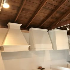 a kitchen with white appliances and wooden ceiling