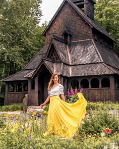 a woman standing in front of a building with a long skirt around her waist and legs