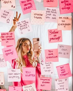 a woman taking a selfie with her cell phone surrounded by sticky notes and handwritten words