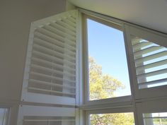 an open window with white shutters on it