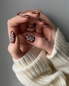 a woman's hands with brown and white manies holding onto her fingers,