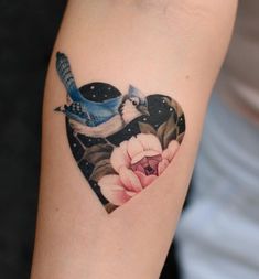 a heart shaped tattoo with two birds on it