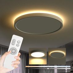 a hand holding a remote control in front of a ceiling light that is lit up