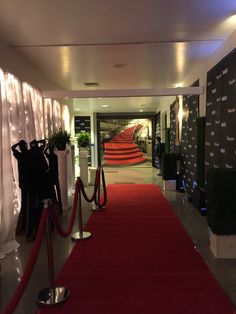 a red carpet is on the ground in front of a building with white walls and stairs