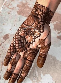 a henna is shown on the palm of someone's hand with intricate designs