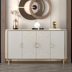 a white and gold sideboard with two circular mirrors on it's wall above it