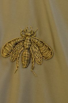 a close up of a bee embroidered on a shirt