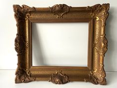 an ornate gold frame on a white wall