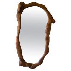 an oval mirror made out of wood on a white background with the reflection in it