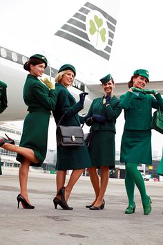 four women in green uniforms are standing on the tarmac