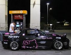 a hello kitty car parked at a gas station