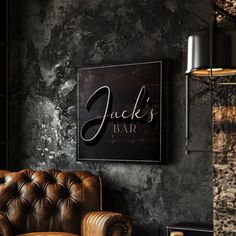 a leather chair sitting in front of a sign that says jack's bar on the wall