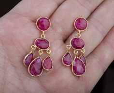 An exquisite piece of art work, this pair of three-tier genuine ruby earrings would be nice reward for yourself or a great gift for your mother or best friend.Each one has three layers of natural ruby stones set in leaflet shaped, gold plated bezels and laid in a dangling willow branch pattern.1. Stones : ruby (natural gemstone)2. Stone shape and size:     top tier: a bezeled round ruby 10mm    middle tier: a bezeled oval ruby 14 x 10 mm    bottom tier: three dangling pear shaped ruby 14 x 11 mm Handmade Chandelier Earrings For Anniversary, Handmade Round Chandelier Earrings For Anniversary, Elegant Ruby Chandelier Dangle Earrings, Ruby Drop Chandelier Earrings As Gift, Handmade Ruby Dangle Earrings, Elegant Ruby Chandelier Earrings For Gift, Dangle Gemstone Chandelier Earrings As Gift, Ruby Gemstone Dangle Jewelry, Ruby Dangle Earrings As Gift