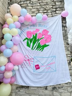 there is a banner with balloons and flowers on it