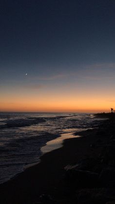 the sun is setting over the ocean and beach