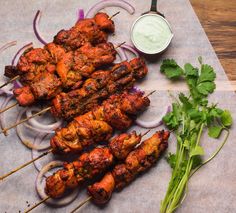 chicken skewers with onions, cilantro and ranch dressing on a cutting board