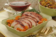 two dishes with meat, vegetables and sauces on the table