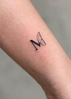 a small butterfly tattoo on the right arm and leg, with an arrow in the middle