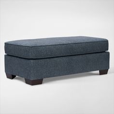 a blue ottoman sitting on top of a white floor