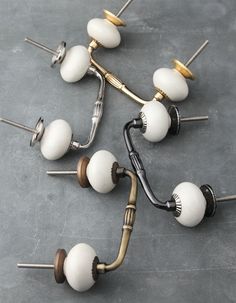 several white and gold knobs are attached to metal pins