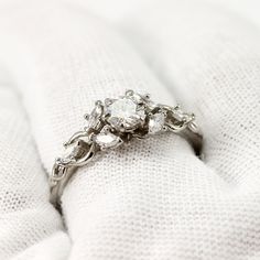 a diamond ring sitting on top of a white blanket