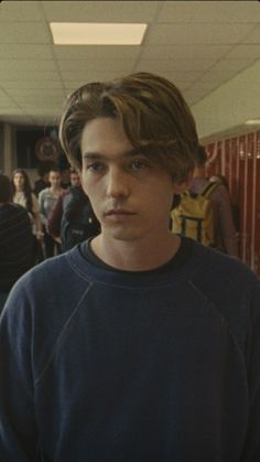 a young man standing in front of a group of people