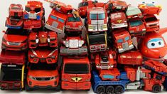 a pile of red toy cars sitting on top of each other next to each other