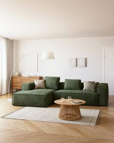 a living room with a green couch and wooden coffee table in the middle of it