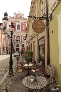 an empty street with tables and chairs in front of a building that says wernada