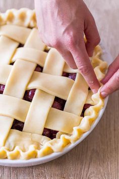 a person placing a pie crust on top of it