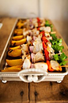 an assortment of skewered meats and vegetables on a tray