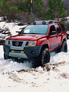 a red truck is driving through the snow