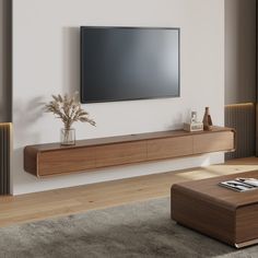 a living room with a large flat screen tv mounted on the wall next to a wooden coffee table