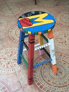 a child's stool made out of wooden blocks with an image of superman painted on it