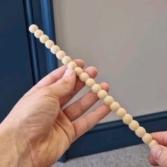 two hands are holding beads in the shape of a long string that is connected to each other