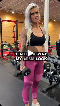 a woman in pink leggings and black bra top standing next to a gym machine