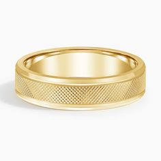 a yellow gold wedding band with an intricate design on the inside and outside, set against a white background