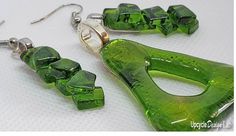 a pair of green glass earrings with silver earwires on a white table top