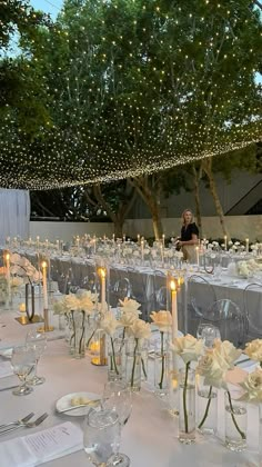 the tables are set with candles and centerpieces for an elegant wedding reception at night